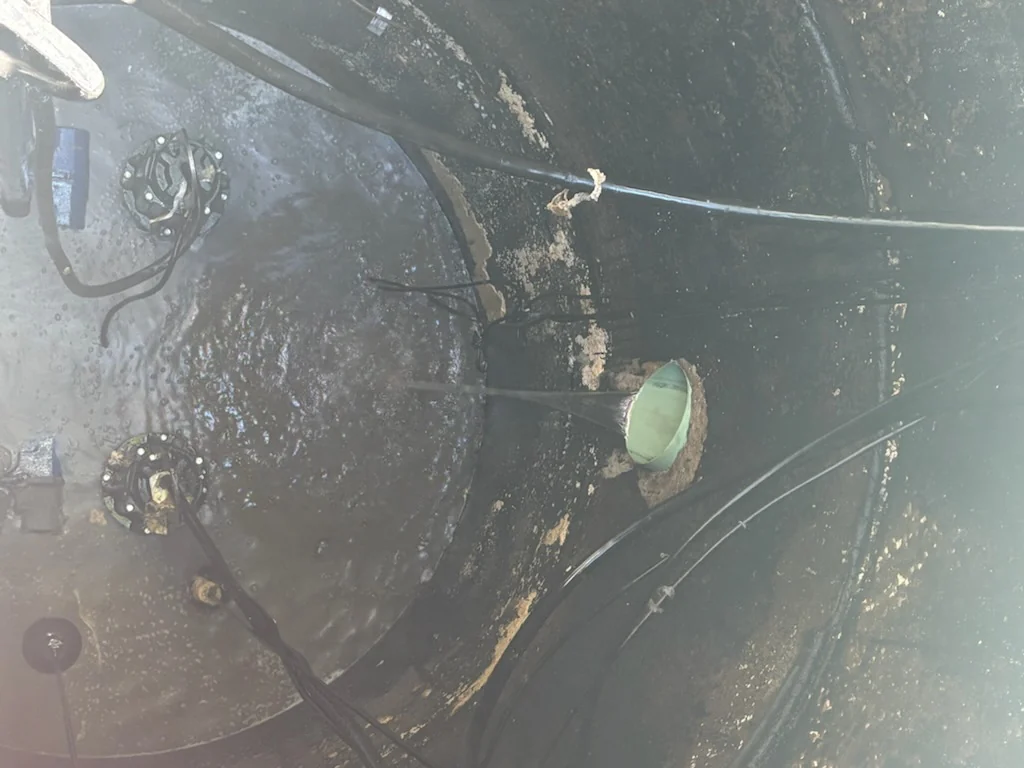 Top down view of operating submersible pumps inside a lift station basin