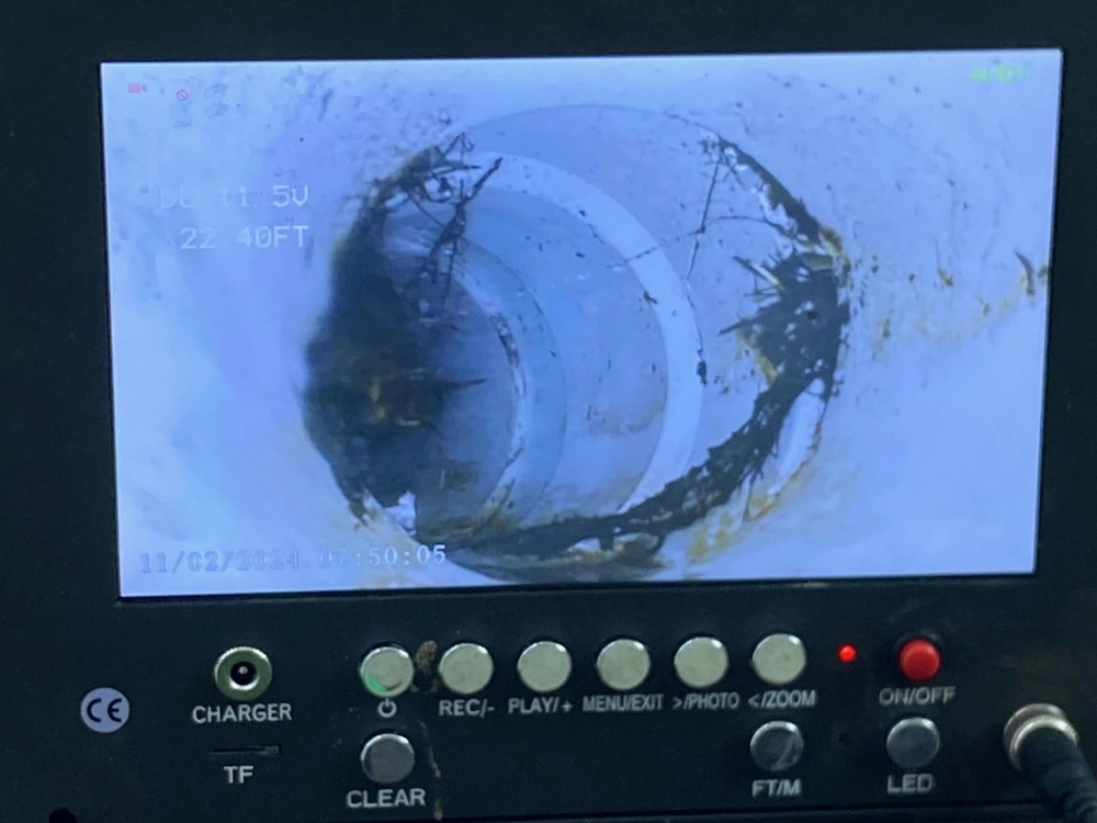 Sewer camera monitor showing a massive root intrusion blocking a pipe