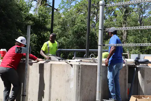 Crew members talking through the next step at the edge of the concrete treatment basin