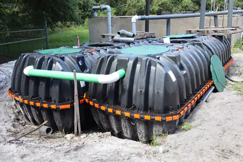 Close view of the two new polyethylene septic tanks with green access lids and a PVC crossover